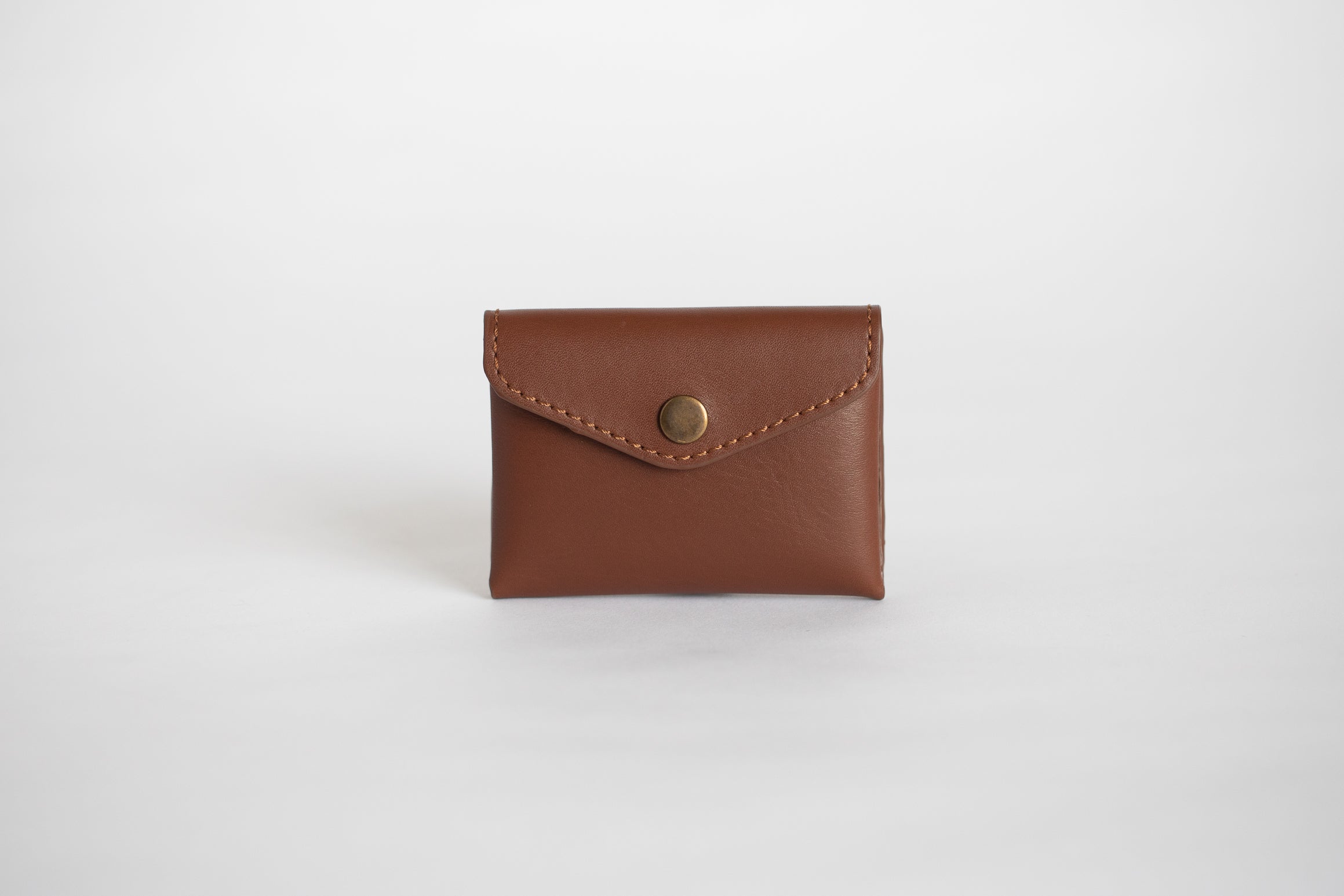 Parnès - A minimalist envelope purse made from a single piece of Cretan  leather and hand printed in our workshop. Each purse comes with two  different leather straps, one to transform this